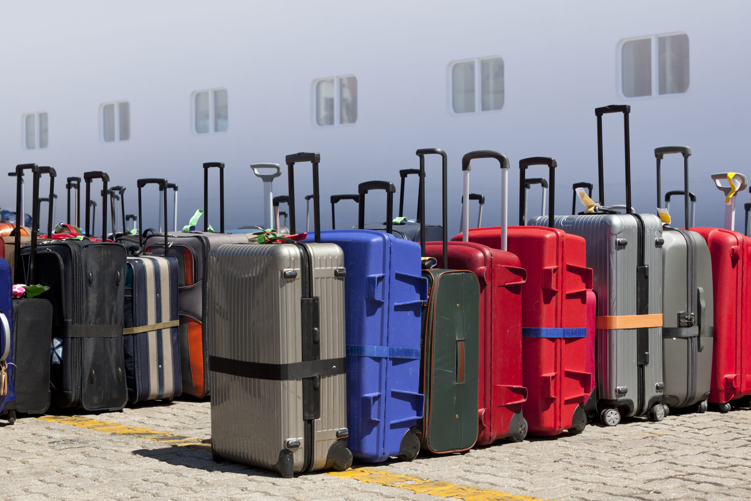 Luggage ready for departure in front of cruising ship